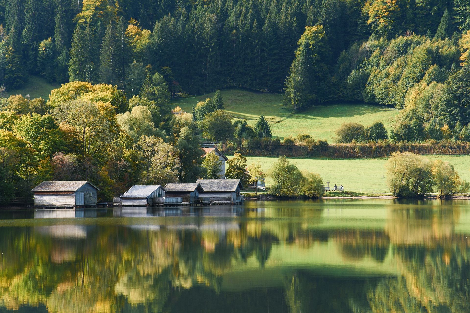 Spiegelglatter Schliersee mit Bootshütten und Herbstwald bei Fischhausen